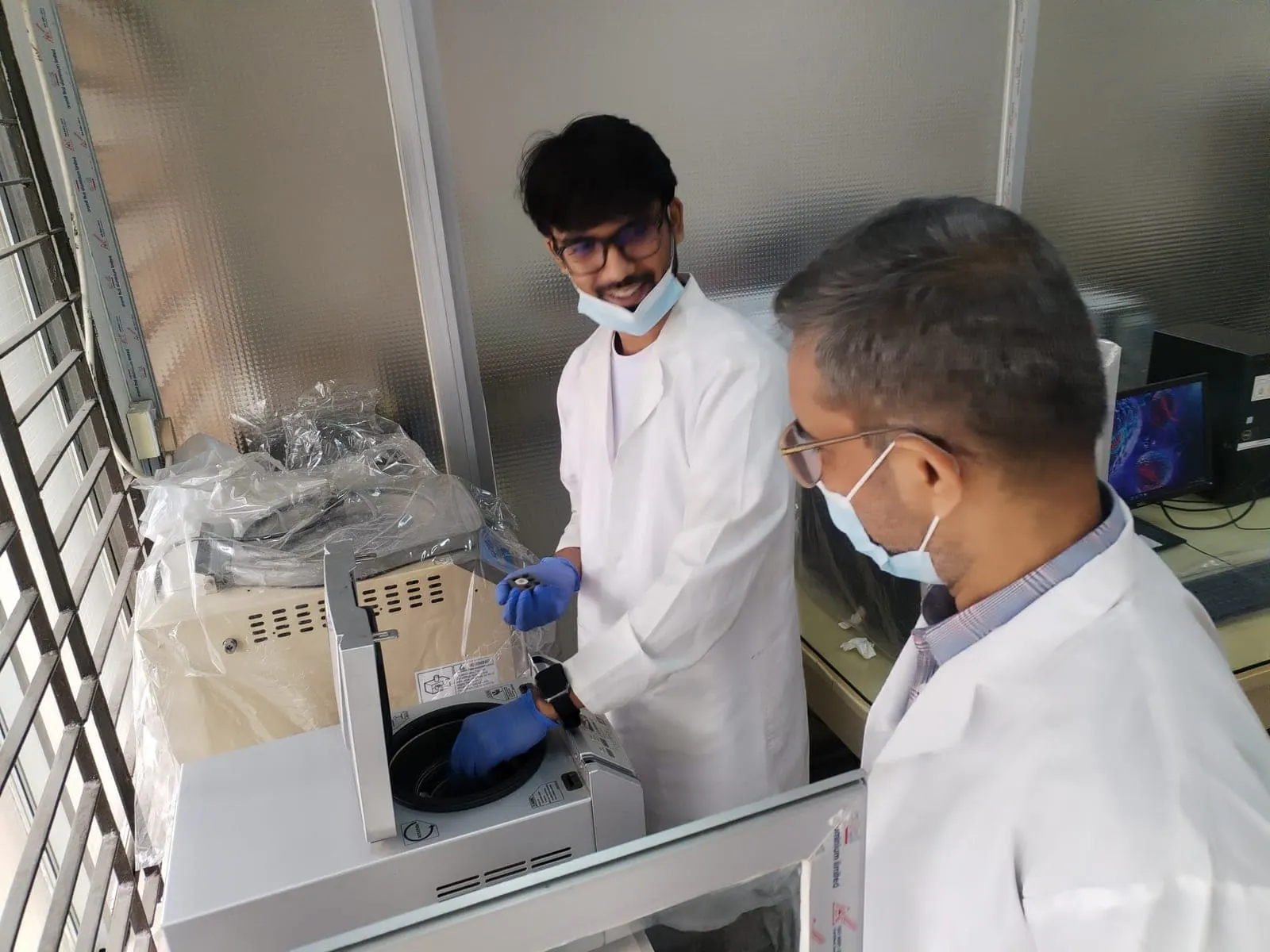 Preparing samples at the benchtop centrifuge with a colleague.